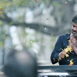 Actor Vijay waves to fans after coming out of CBI office