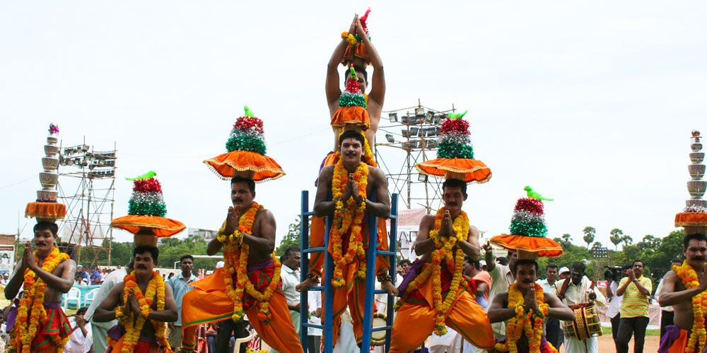 தலையில் குடம் வைத்து கரகாட்டம் ஆடும் கலைஞர்
