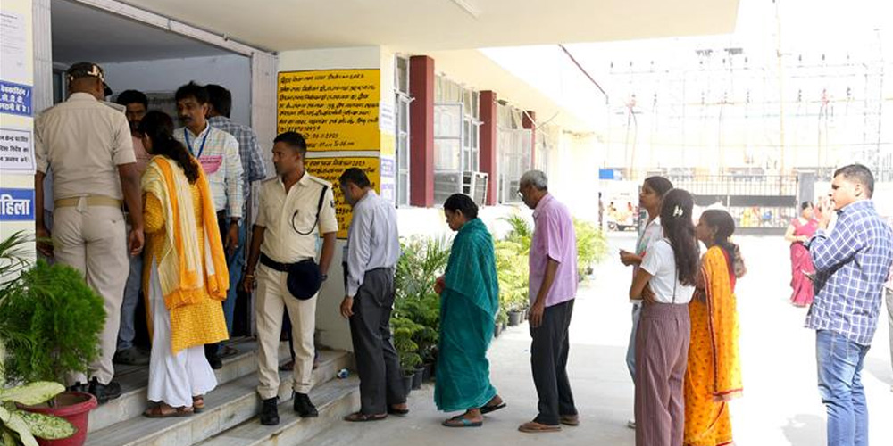 வாக்குச்சாவடியில் வரிசையில் நிற்கும் மக்கள்